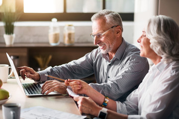 Old man typing while woman pointing at the screen