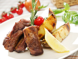 Grilled ribs, French fries and cherry tomato. BBQ pork ribs, american food