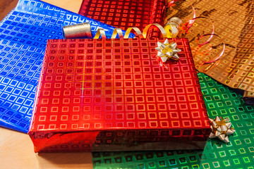 Fototapeta premium Gift wrapped in red paper with golden ribbon