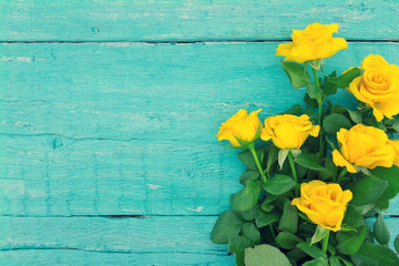 Fototapeta na wymiar Bouquet of yellow roses on turquoise rustic wooden background. V
