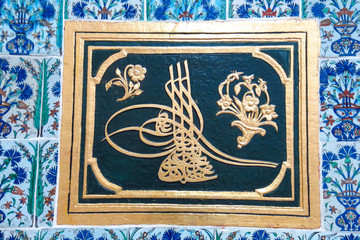 Fototapeta na wymiar Arabic script, named tughra, in a Ottoman tiles. Topkapi Palace, Istanbul, Turkey.