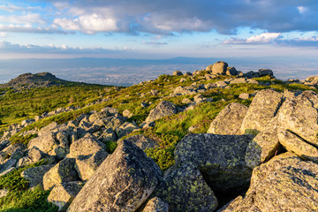 Beautiful sunset at Vitosha, Sofia, Bulgaria - jagged rocky terrain with green meadows and steep slopes - popular Bulgarian tourist destination - warm colors, last rays of sunlight