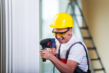Man drilling the wall with drill perforator