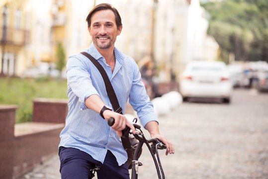 Cheerful man riding a bike