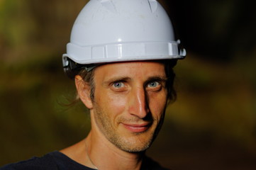 portrait of a worker with white helmet on head,  nature background