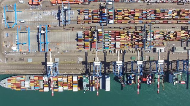 Commercial port with container ship - Top down Aerial footage across the platform