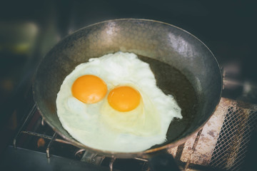 Fried eggs in a pan on a gas stove