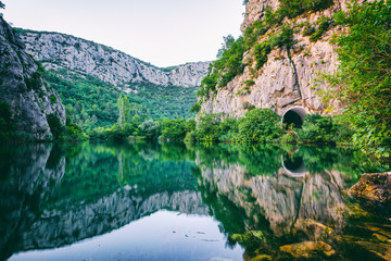 Fototapeta na wymiar Beautiful green canyon of the river Cetina with rocks, stones and reflection in a water, summer landscape, Omis, Croatia