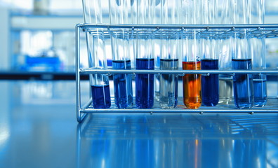 orange and blue chemical solution in test tubes in science lab