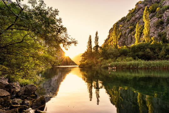 Sunset over the canyon of river Cetina with trees, rocks and reflection in a water, beautiful landscape, Omis, Croatia