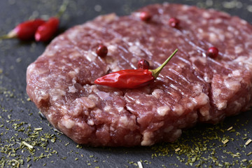 raw burger on a slate surface