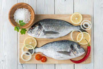fish with spices on a wooden background