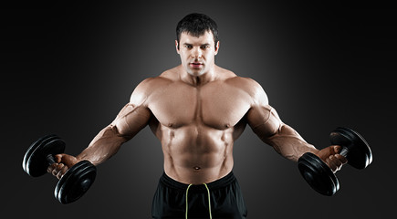 Fototapeta na wymiar Portrait of bodybuilder with dumbbells