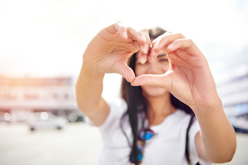 Romantic young woman making a heart gesture