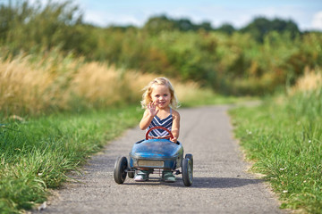 kleines Mädchen hat Spaß beim Fahren mit dem Tretauto