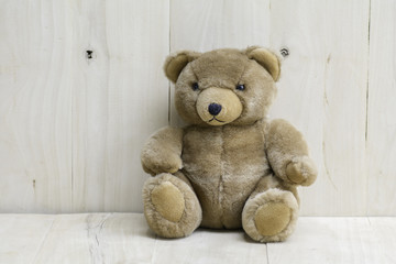 Brown teddy bear on wooden floor