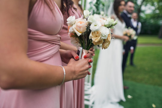 Bouquet of flowers in the hand of the bridesmaid