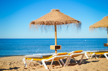 Blue sky and straw umbrella on a beautiful tropical beach background