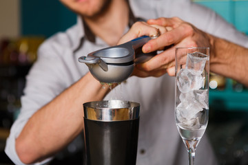 Barman's hands making cocktail with egg yolk
