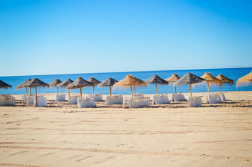 Fototapeta premium Blue sky and straw umbrella on a beautiful tropical beach background