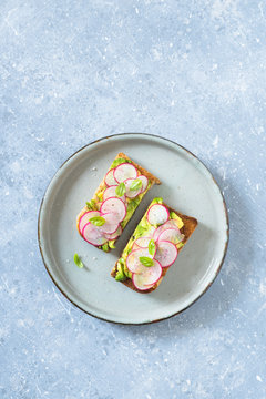 Avocado and radishes sandwich. Overhead view, copy space.