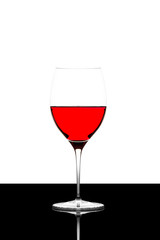 red wine glass on a  black board isolated and backlit
