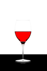 red wine glass on a  black board isolated and backlit