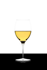 white wine glass on a  black board isolated and backlit