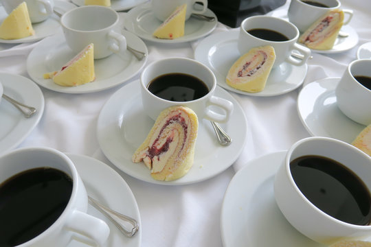 take a break- swiss rolls and coffee on white table