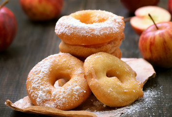 Apple rings over baking paper on wooden table