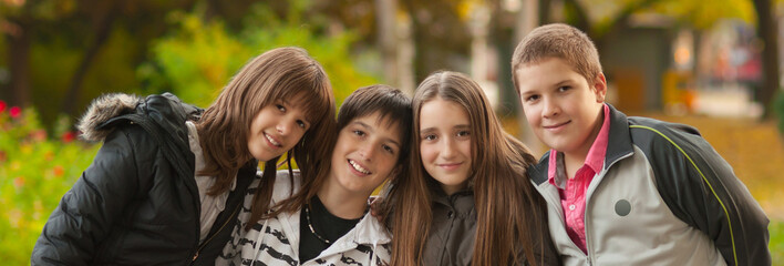 Teenage boys and girl having fun together in autumn park