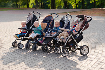 funny children sitting in strollers in park