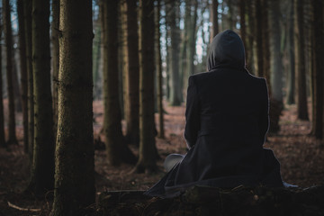 Silhouette von sitzender Person im Wald