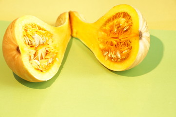 Yellow and ripe pumpkin lie on a bright background
