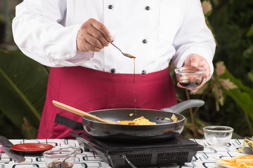 Chef putting soy sauce for cooking /