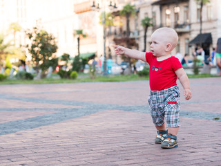 Naklejka premium Young mother with her toddler son playing outdoors in city