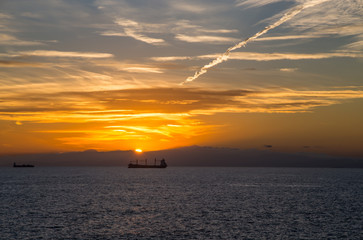 Naklejka na ściany i meble Boats on the horizon at sunset