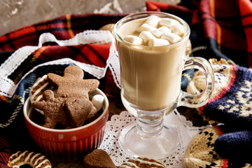Christmas coffee with milk and marshmallow. Red dowl with homemade cookies.