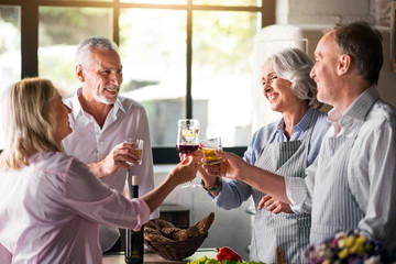 Family cheering with whiskey and wine in kitchen