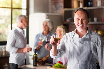 White middle-aged cook saying a toast looking at camera