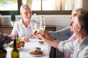 Group of friends toasting with champagne in the kitchen