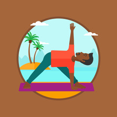 Obraz na płótnie Canvas Man practicing yoga triangle pose on the beach.