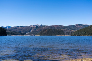 Shudu Lake and mountain range in Pudacuo national Park located at Shangri-La (Zhongdian), Yunnan, China.
