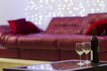 Interior with a coffee table, a sofa and a bottle of wine
