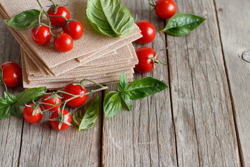 Raw lasagna sheets,basil and cherry tomatoes