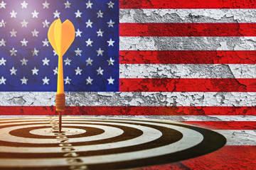 target dart with arrow over blurred  America flag on clacked wall background.