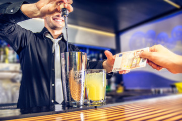 Bartender taking money from the customer.