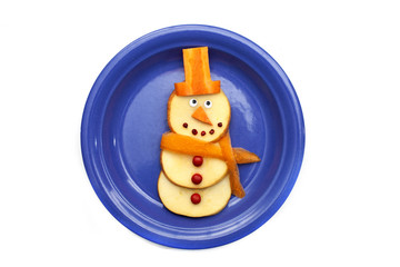 Food art creative concepts. Cute Christmas decoration made of fruits and vegetables over a white background.