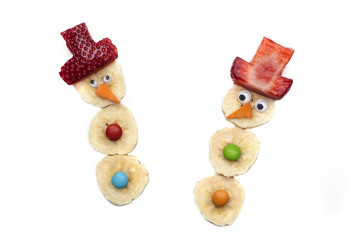 Food art creative concepts. Cute Christmas decoration made of fruits and vegetables over a white background.