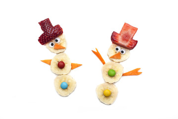 Food art creative concepts. Cute Christmas decoration made of fruits and vegetables over a white background.